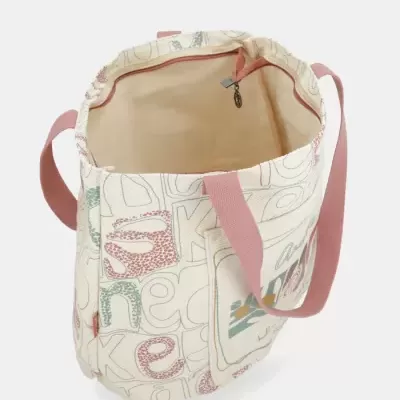 Mala de tecido cru com alças cor de rosa e padrões gráficos coloridos