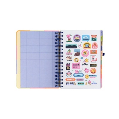 Caderno aberto com página de autocolantes coloridos em português e página com quadrícula azul clara