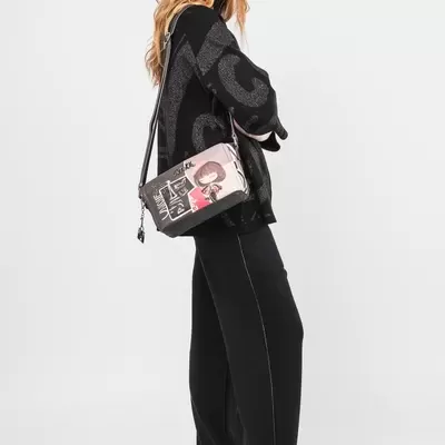 Mulher com roupas pretas e mala de tiracolo colorida