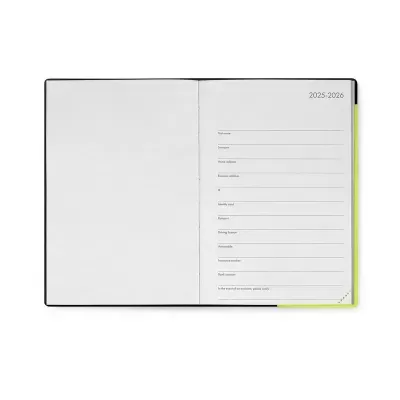 Agenda ou caderno aberto com capa preta e páginas brancas e texto 2025-2026