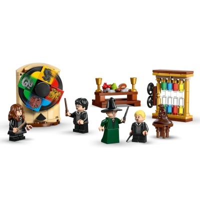 Conjunto LEGO com figuras, roda de símbolos, mesa com comida, chapéu e estrutura com frascos coloridos.