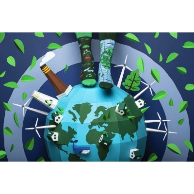 Pares de meias estilizadas verdes e azuis com padrões ambientais sobre globo de papel azul e verde, rodeado por moinhos, árvores e folhas.