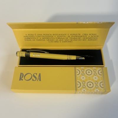 Conjunto de caneta amarela em caixa amarela com texto em português no interior da tampa