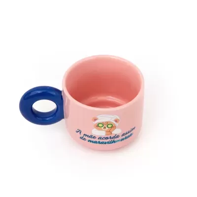 Caneca rosa com asa azul e desenho de urso e texto em português