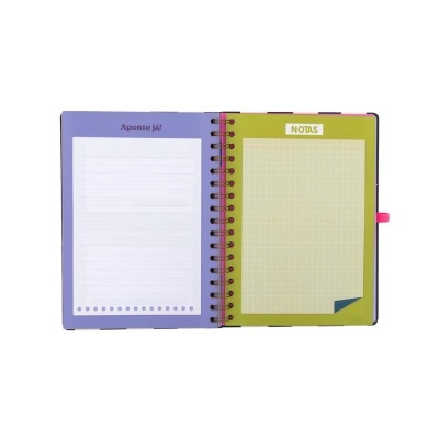 Caderno aberto com páginas para notas e linhas, cores lilás e verde, suporte para caneta rosa.