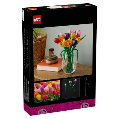 Caixa LEGO com ramo de tulipas coloridas em peças plásticas num vaso transparente, sobre mesa com livro e objetos.
