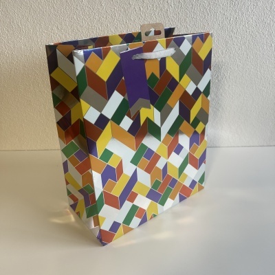 Saco de papel com padrão geométrico colorido e pegas de corda brancas