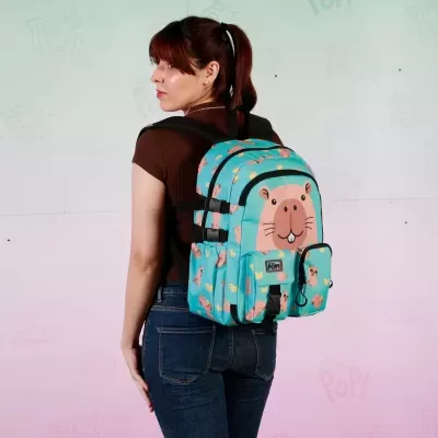 Mochila azul turquesa com desenho de castor usada por mulher com camisa castanha e calças jeans