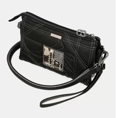 Bolsa preta de mão com costuras brancas e placa decorativa com padrão abstrato