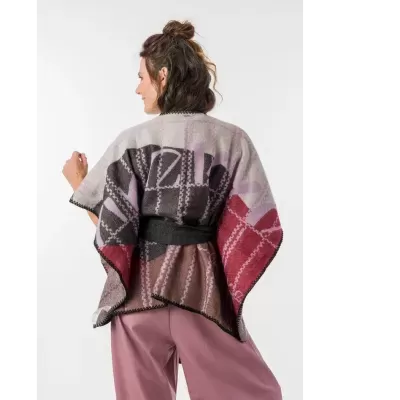 Poncho de malha colorido com padrão geométrico em mulher vista de costas