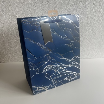 Saco de papel azul com padrão de mármore prateado e cartão castanho