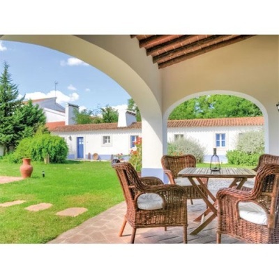 Conjunto de móveis de exterior em varanda com vista para jardim e casas brancas