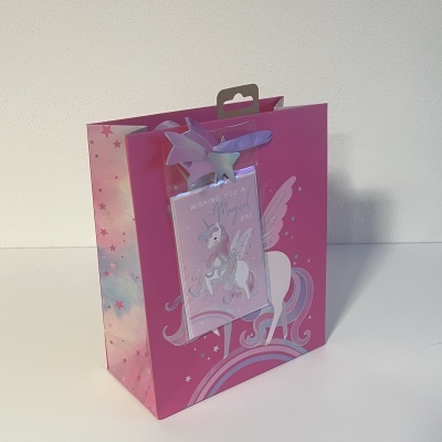 Saco de presente rosa com unicórnio, asas e etiqueta 'WISHING YOU A Magical day'