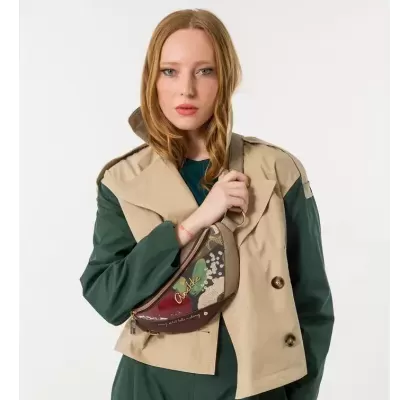 Mala floral colorida Anekke usada por mulher com vestido verde e colete bege.