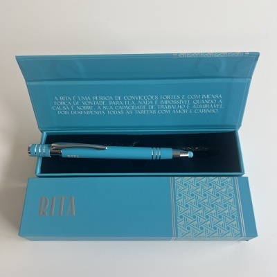 Caneta azul em caixa azul com texto em português e padrão geométrico