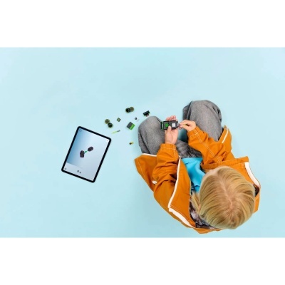 Criança a montar brinquedo robô com tablet ao lado