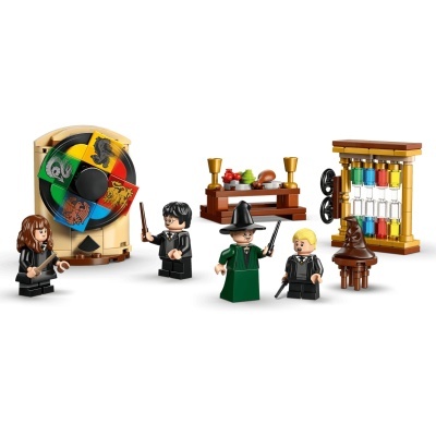 Figuras LEGO com personagens, chapéu de feitiçaria, tabuleiro giratório com brasões e tubos coloridos.