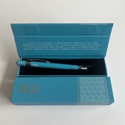 Caneta azul dentro de estojo azul com texto em português no interior da tampa