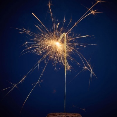 Vela de aniversário tipo faísca com faíscas douradas num bolo