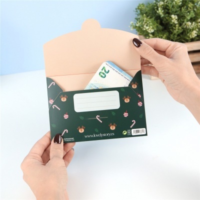 Envelope de Natal verde com padrão festivo e nota de 20 euros dentro