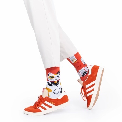 Meias vermelhas com estampas de gato e sapatilhas adidas Gazelle laranja com detalhes brancos