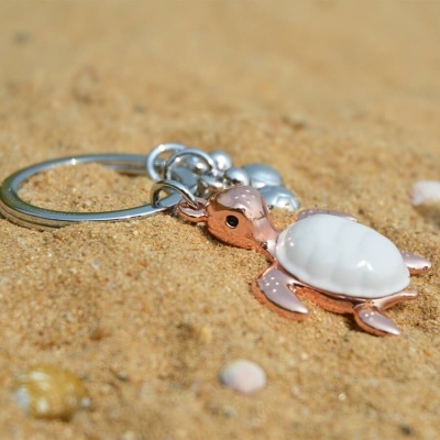 Chaveiro tartaruga cobre e branco sobre areia