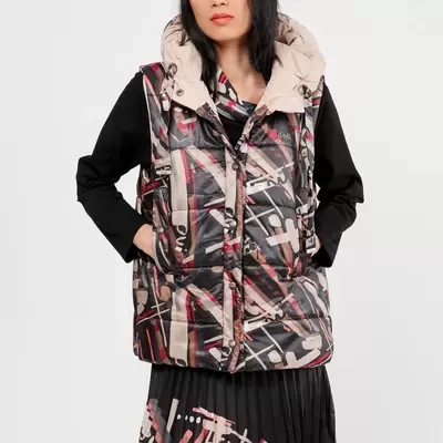 Mulher a usar colete acolchoado com padrão geométrico e capuz bege.