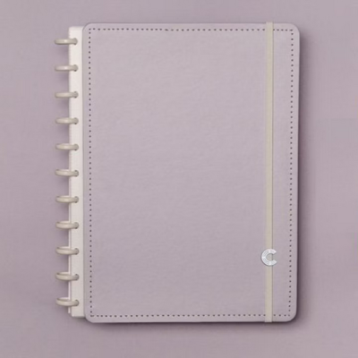 Caderno rosa claro com capa rígida, elástico creme e argolas de plástico branco