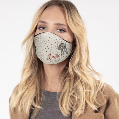 Mulher loira a usar máscara facial bege com pontos pretos e ilustração de animal, texto Anekke