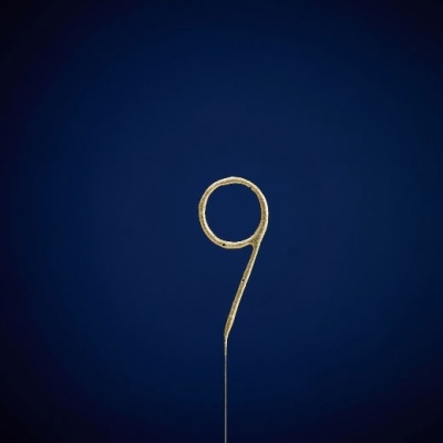 Número 9 em metal dourado em fundo azul escuro