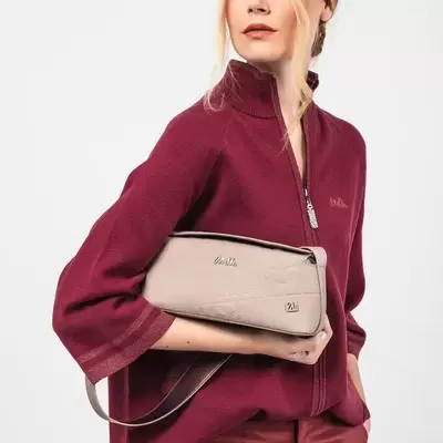 Mulher com camisa vermelha e bolsa bege da marca Chloé