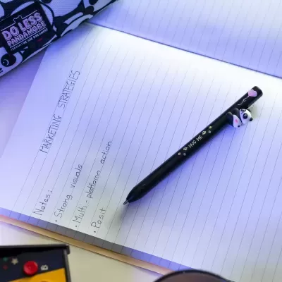 Caneta preta com panda em caderno com anotações sobre estratégias de marketing