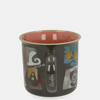 Caneca preta com interior vermelho e padrões coloridos abstratos