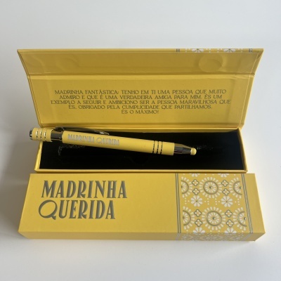 Estojo amarelo com caneta e texto 'MADRINHA QUERIDA' em preto