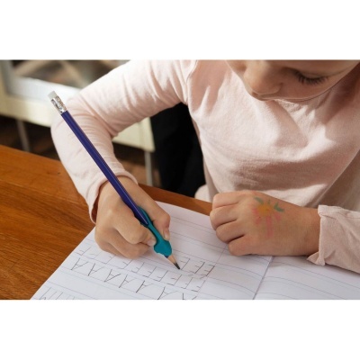 Criança a escrever com lápis azul e pega ergonómica num caderno pautado