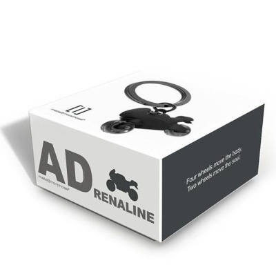 Embalagem branca com porta-chaves de mota preta e texto AD RENALINE.