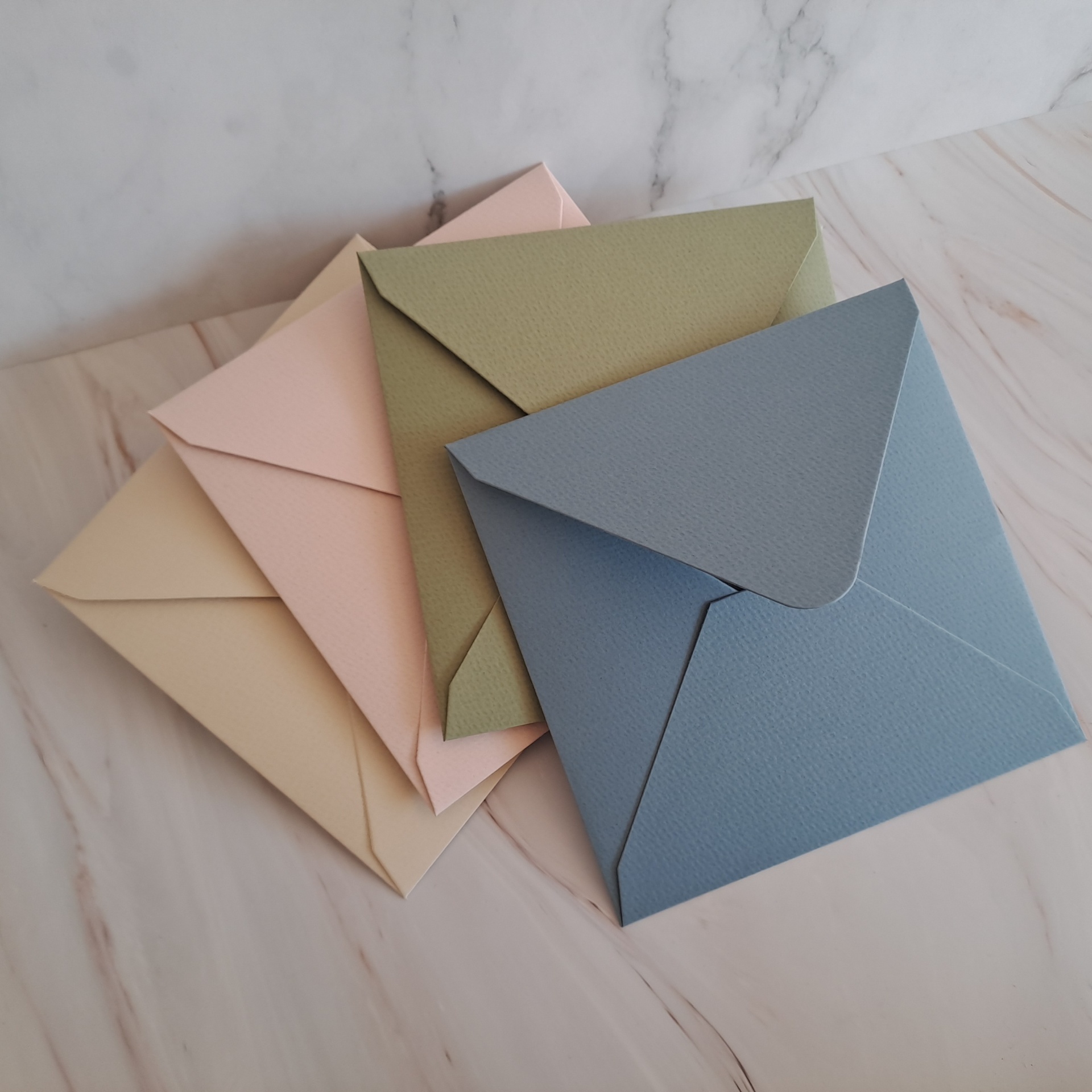 Envelope Prisma Pastel QD16 Conjunto de envelopes coloridos sobre superfície marmoreada