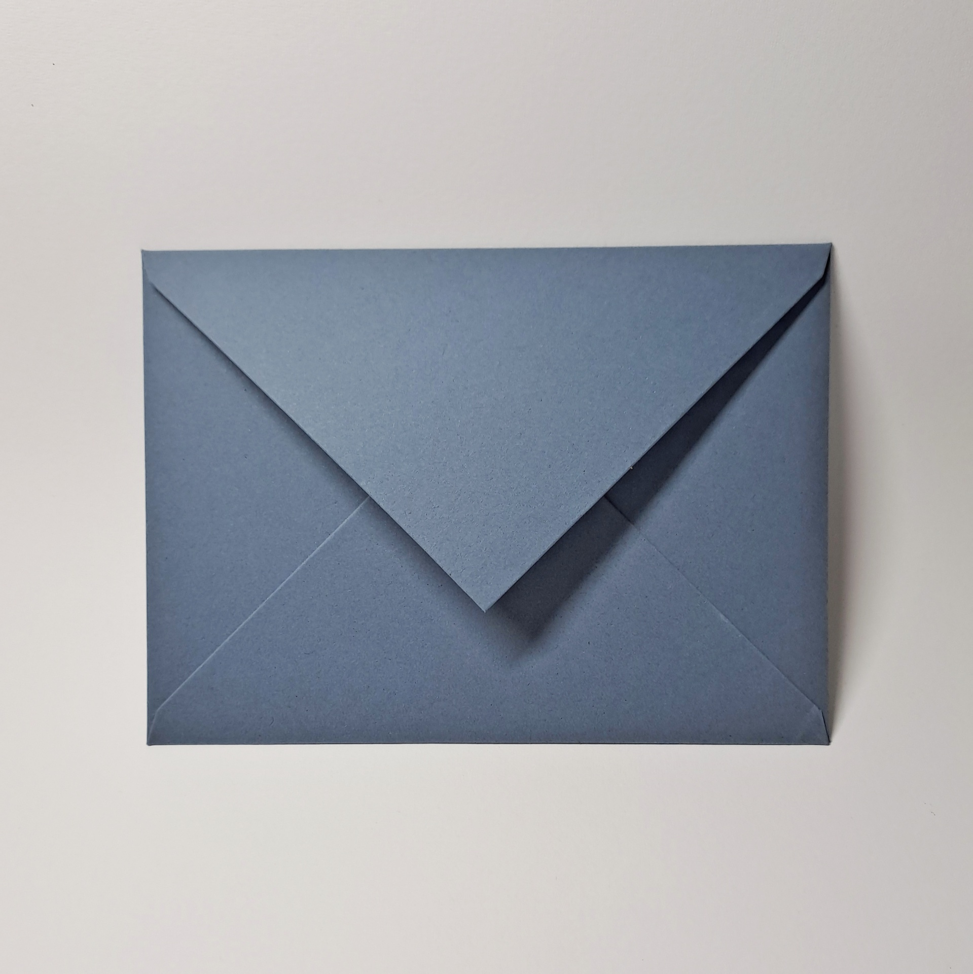 Pacote 25 Envelopes Organic C13 Envelope azul escuro fechado sobre fundo branco