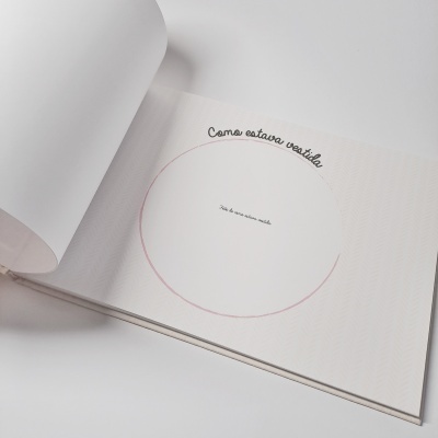 Livro aberto com páginas brancas e texto em português com círculo desenhado e frase 'Como estava vestido'