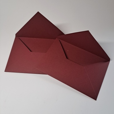 Dois envelopes castanho escuro abertos numa superfície branca