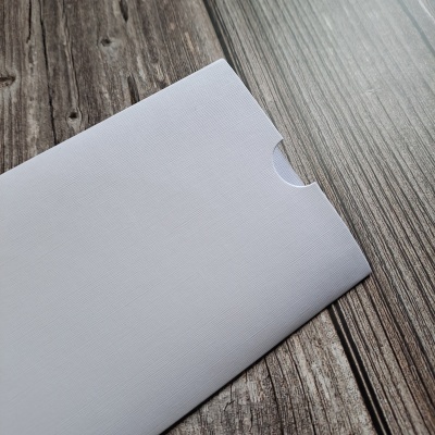 Envelope branco com textura sobre superfície de madeira rústica cinzenta