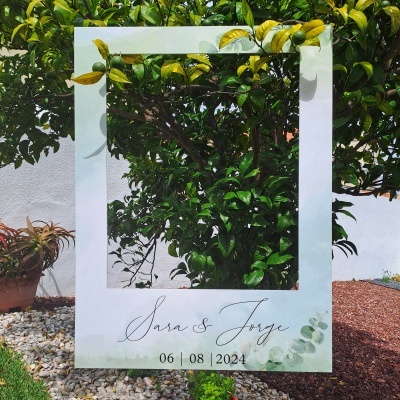 Estrutura fotográfica branca com folhas verdes, texto Sara & Jorge, data 06 08 2024, em arbusto