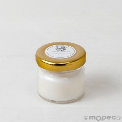 Frasco pequeno de vidro com tampa dourada e etiqueta branca na tampa.