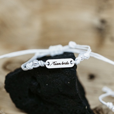 Pulseira branca com placa metálica gravada Team bride sobre pedra negra