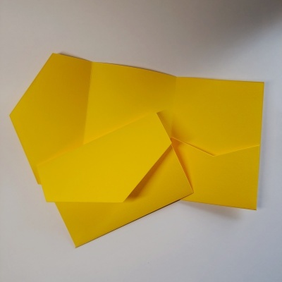 Envelope e papel amarelo sobre superfície branca