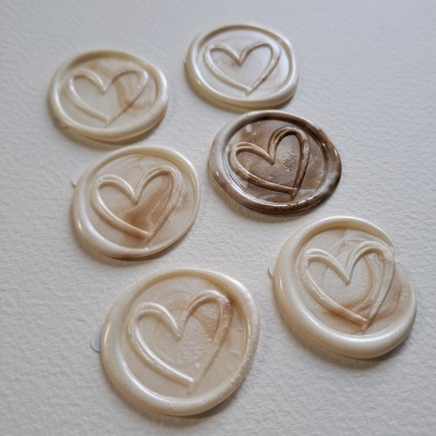 Seis selos de cera com coração gravado em vários tons claros e castanho