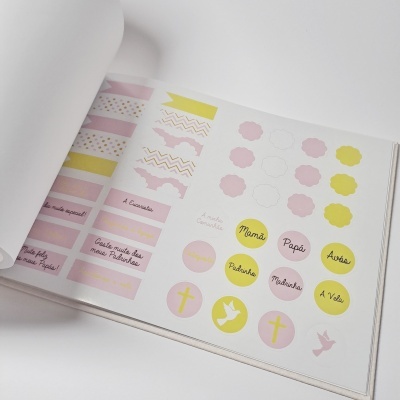 Livro com autocolantes coloridos de várias formas e textos em português.