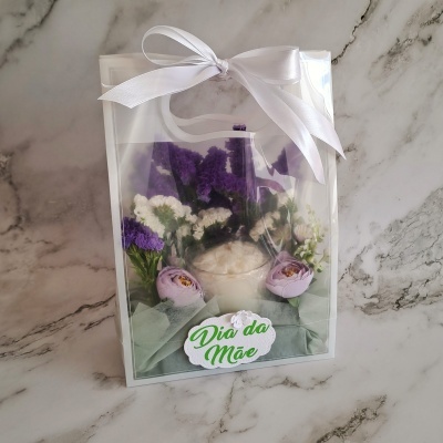 Pack de presente com flores artificiais e laço branco com etiqueta Dia da Mãe