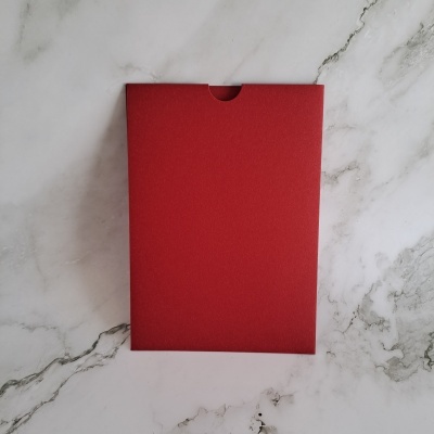 Envelope vermelho sobre superfície marmoreada