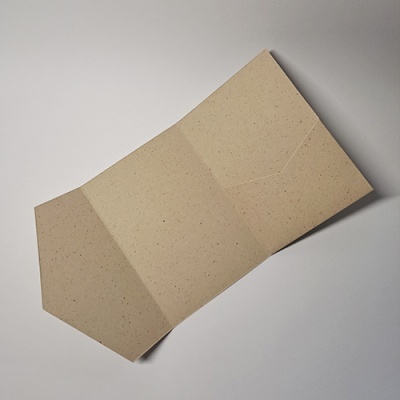 Envelope aberto de papel reciclado bege com textura pontilhada
